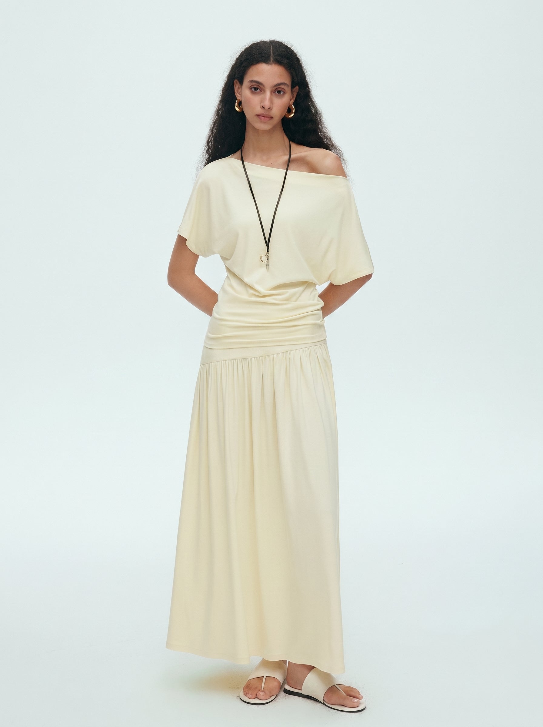 Front view of cream off shoulder draped top and matching maxi skirt set with a soft feminine silhouette