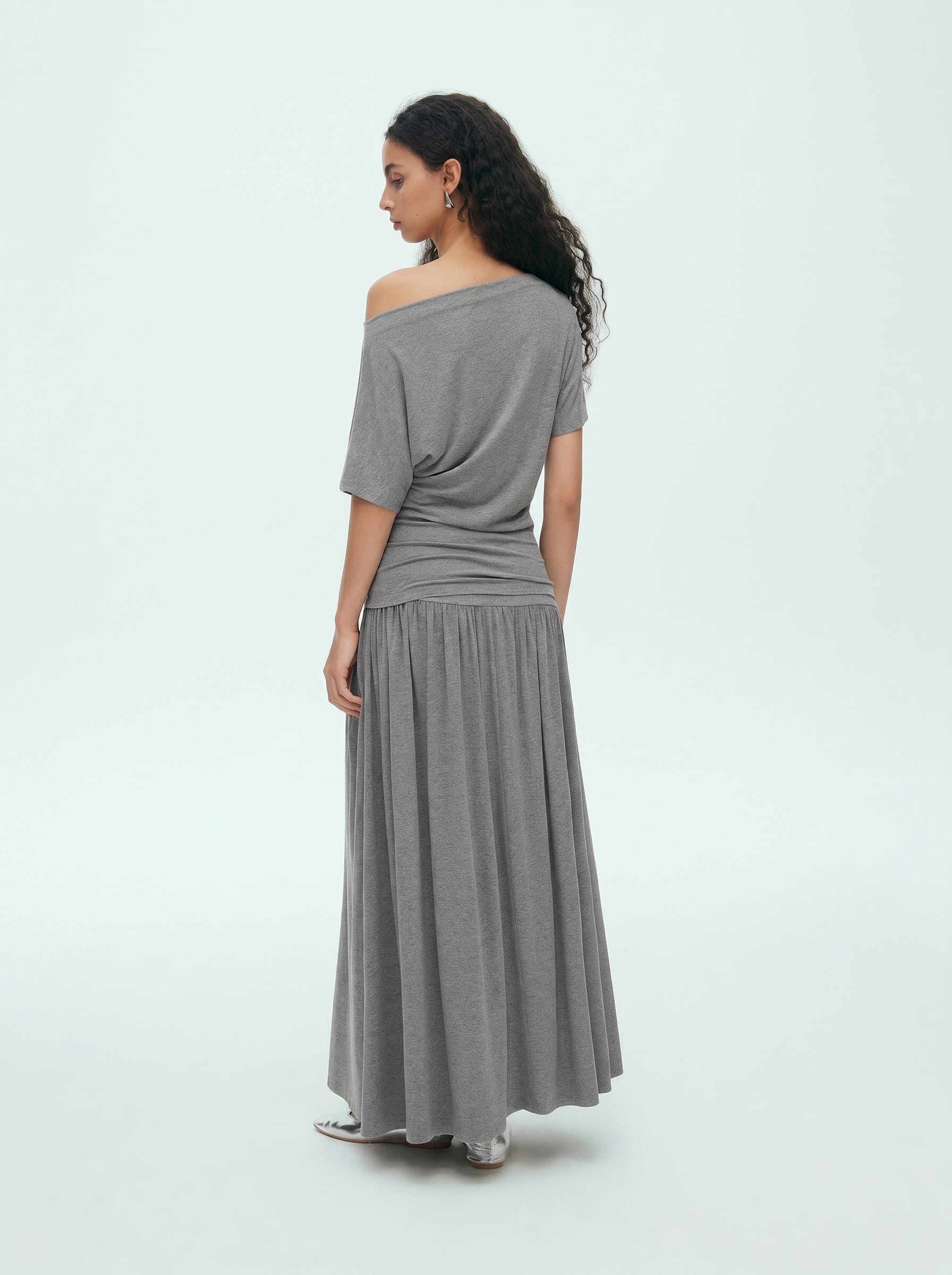 Back view of grey off shoulder draped top and matching maxi skirt set showing the relaxed fit and long skirt silhouette
