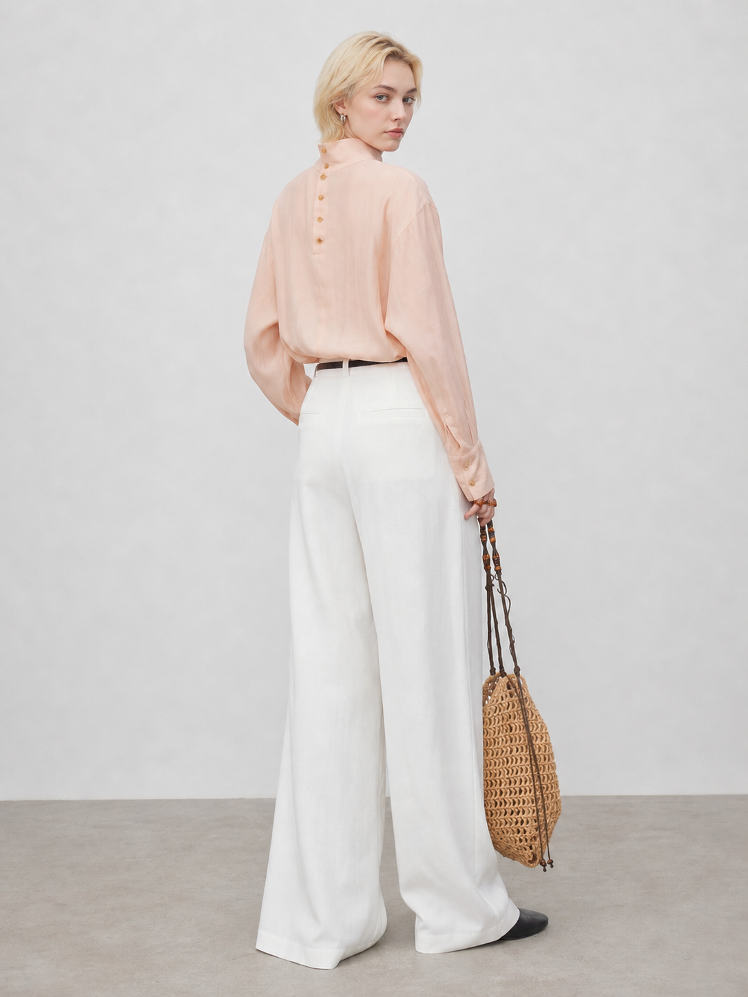 Model wearing peach sheer blouse in a back pose showing rear buttons and airy fabric texture