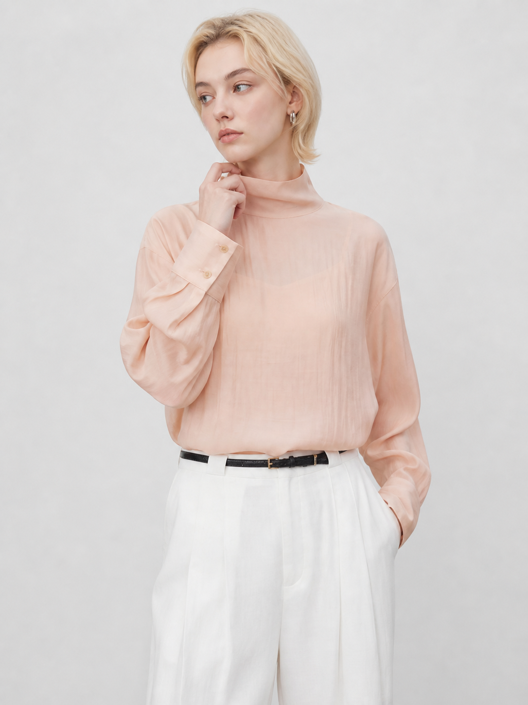 Front detail of peach sheer blouse showing high neckline, translucent fabric, and relaxed sleeves