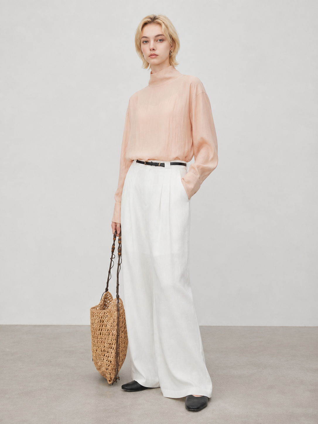 Peach sheer high neck blouse styled with white wide leg pants, black flats, and woven tote