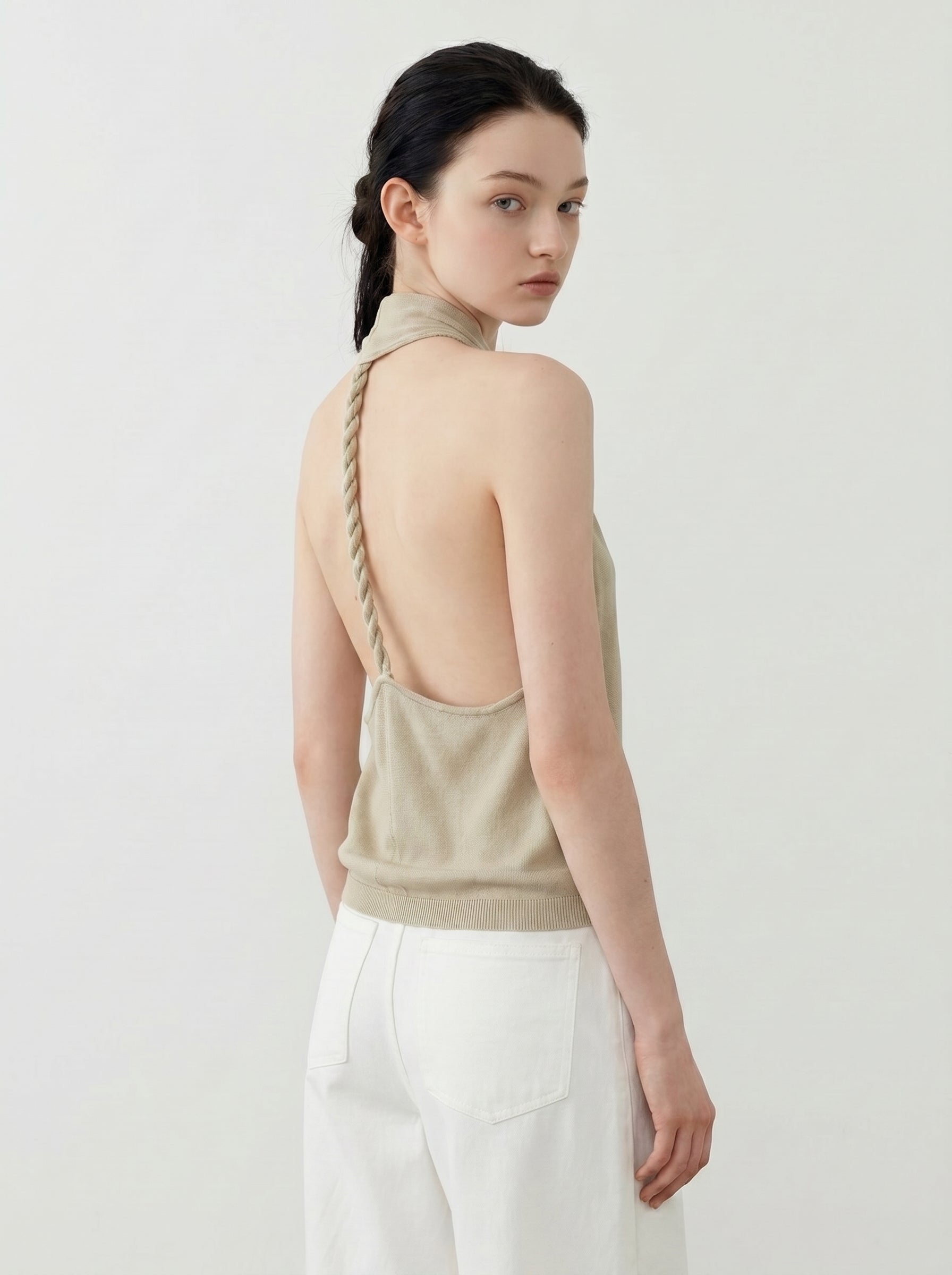 Back view of sage halter knit top showing the braided strap and open back design