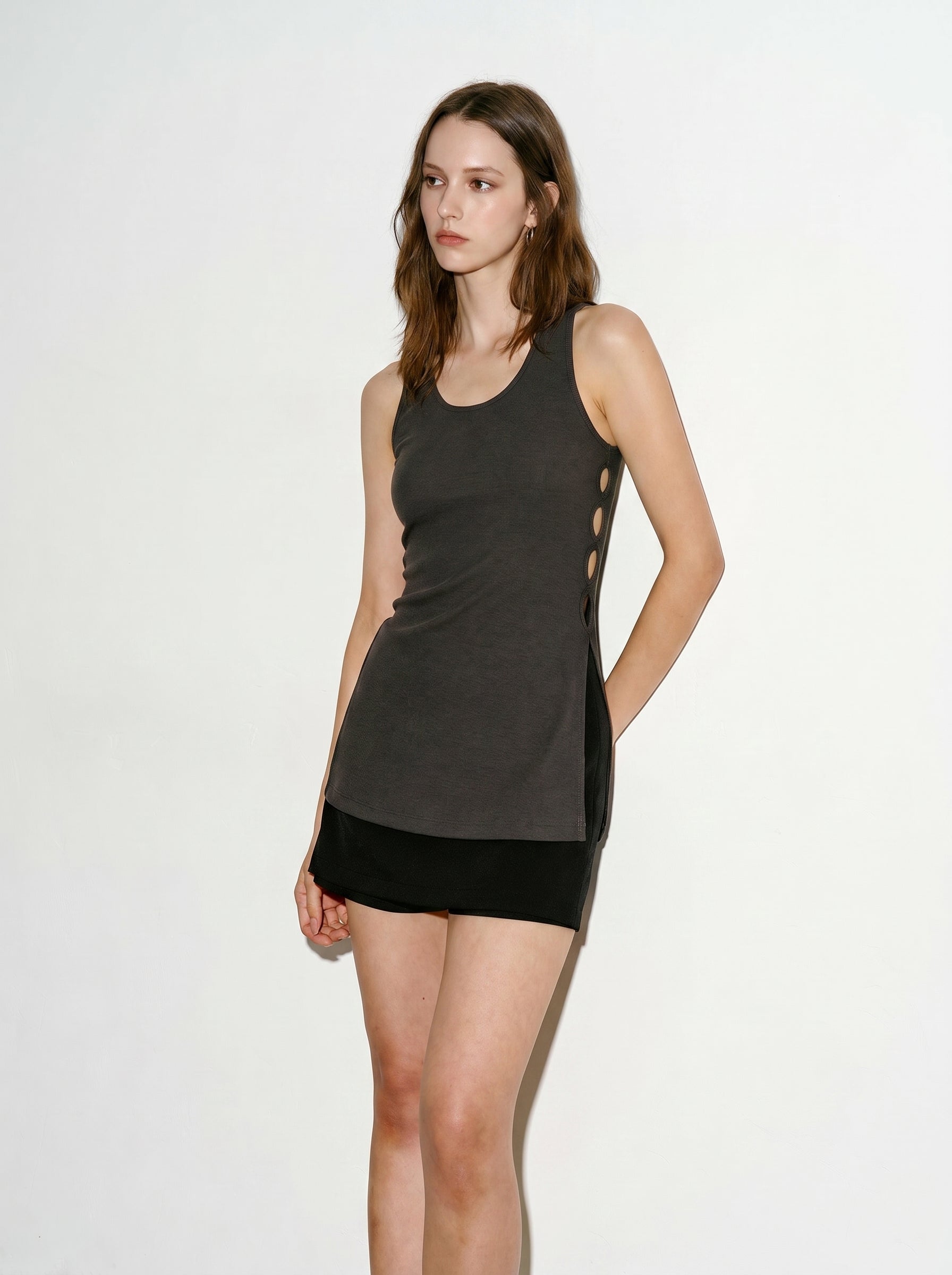 Model wearing a grey side ring ribbed tank top with a black mini skirt and sandals