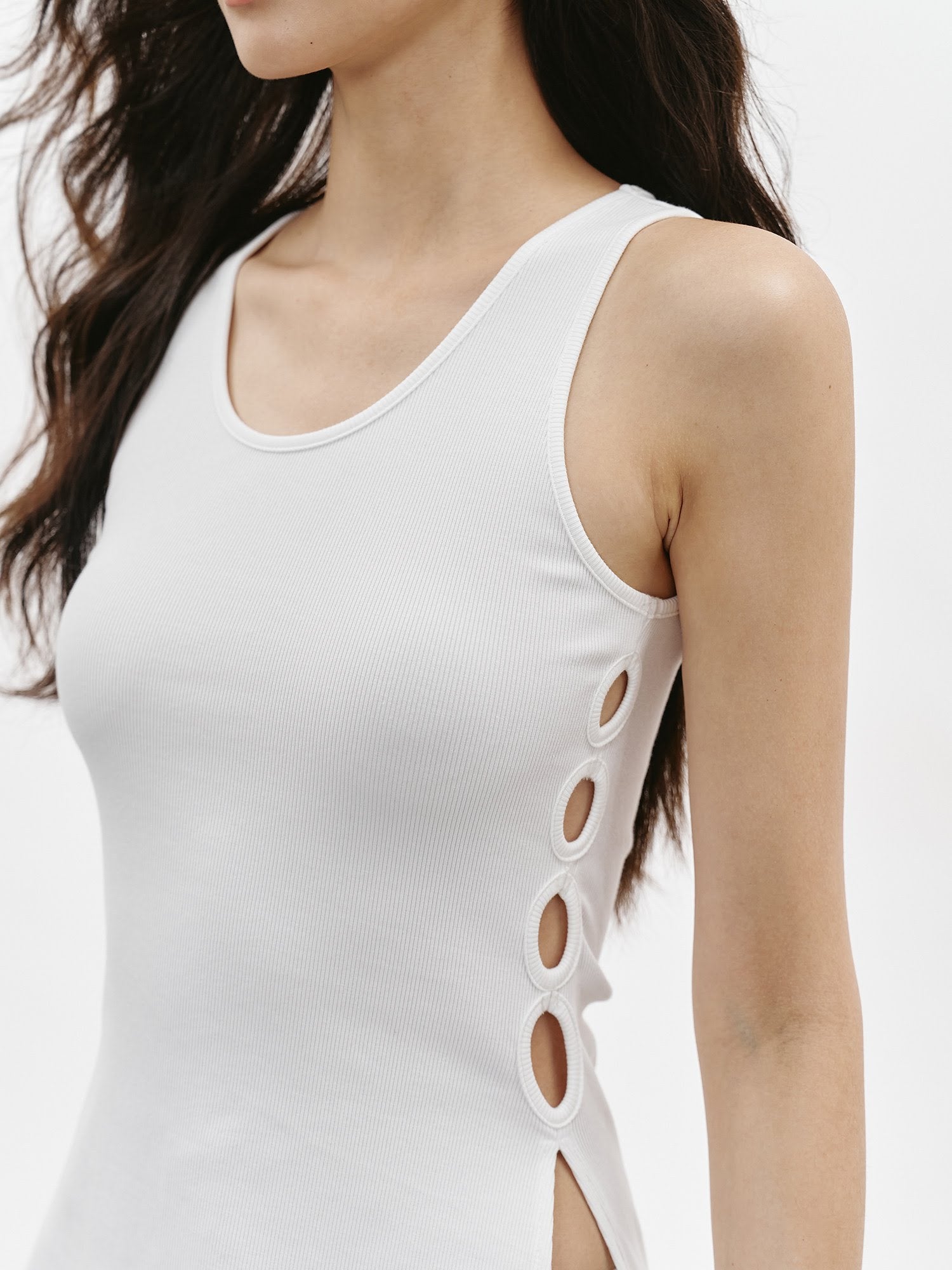 Close-up of white side ring ribbed tank top showing the scoop neckline, slim fit, and side cutout ring detail