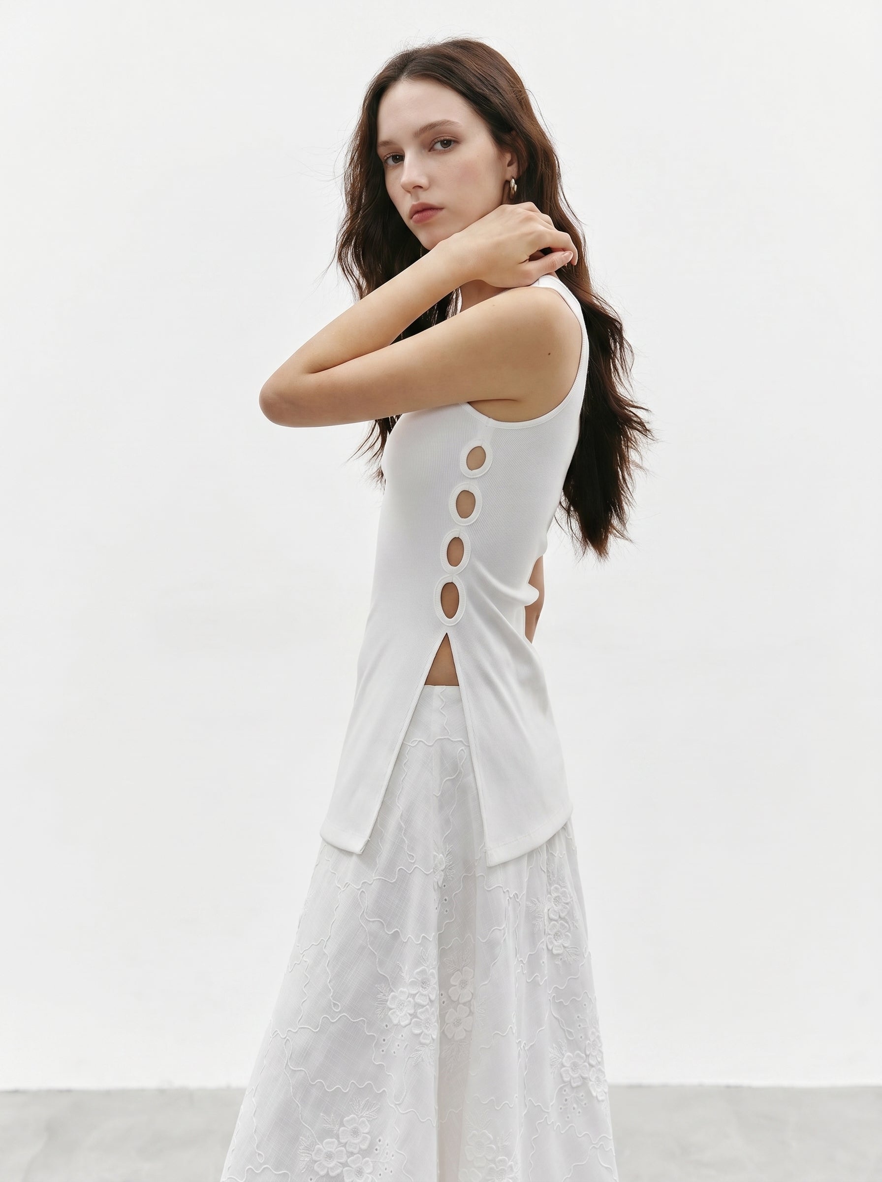 Model wearing a white side ring ribbed tank top with a white maxi skirt, showing the side ring cutout design