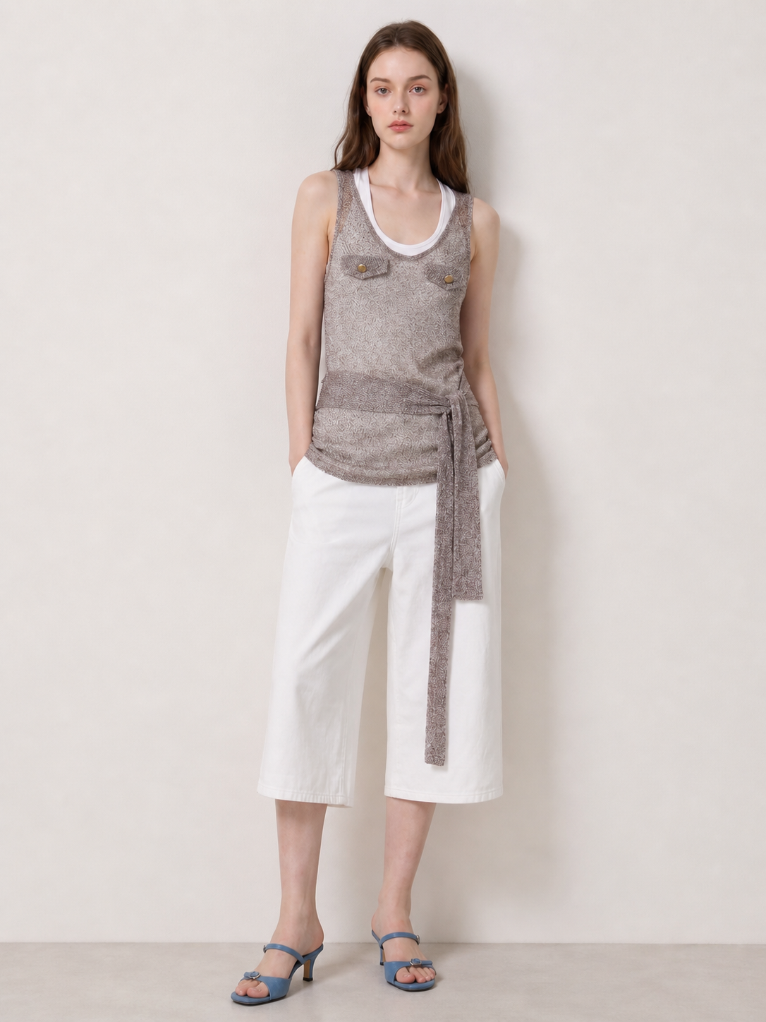 Taupe tie waist sleeveless knit tank layered over a white scoop neck tank with white cropped wide leg pants