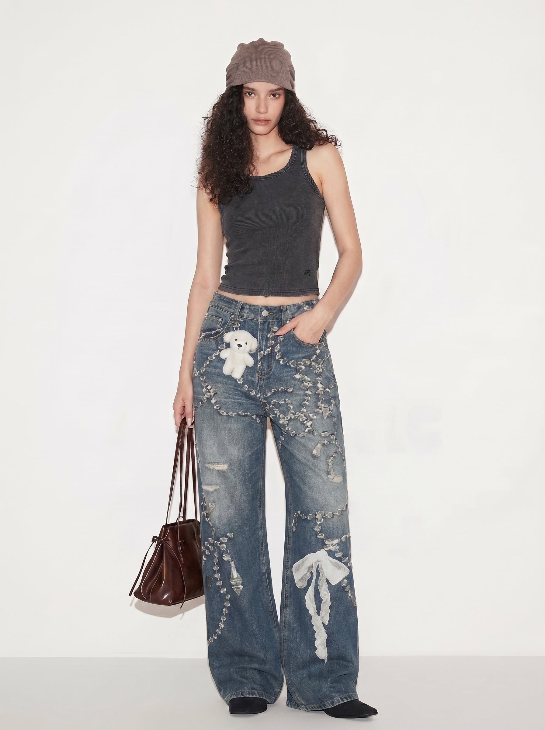 Model wearing washed blue chain graphic wide-leg jeans