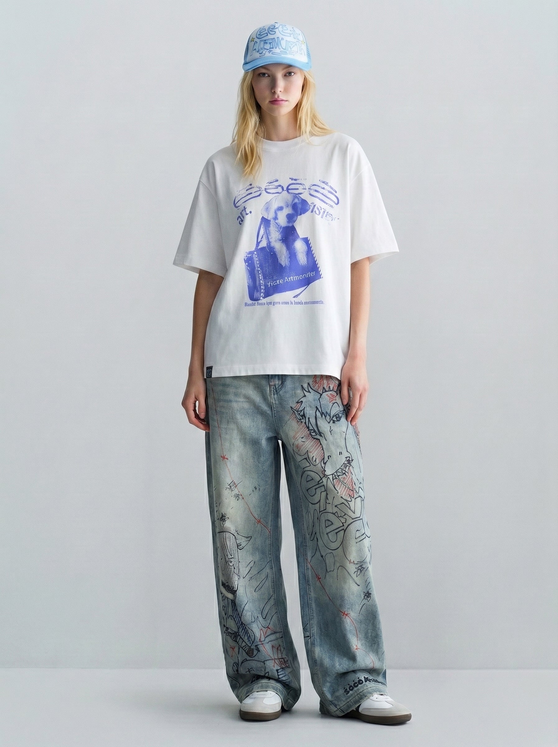 Blonde model wearing an oversized gray dog graphic tee with white polka dot cargo shorts and striped socks