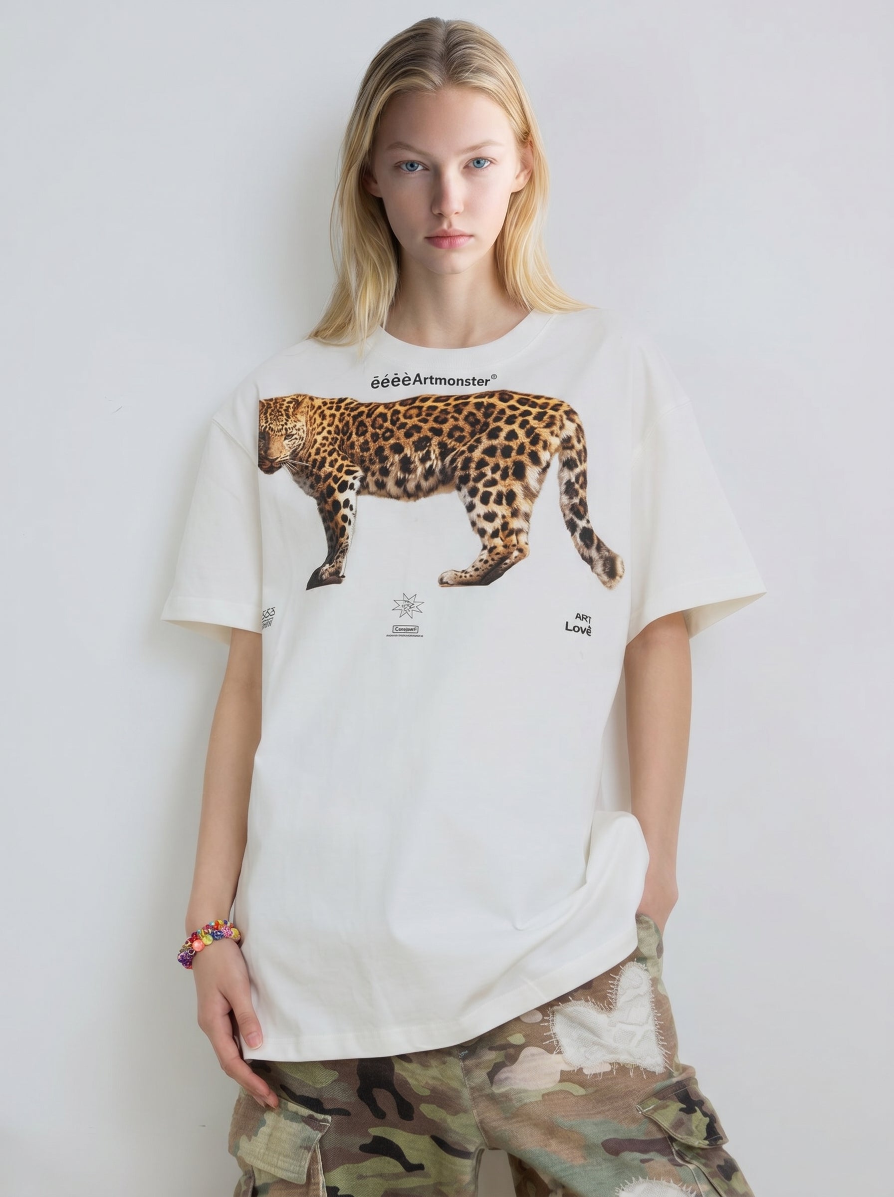 Front detail of white oversized T-shirt featuring a large leopard graphic print and small white logo text