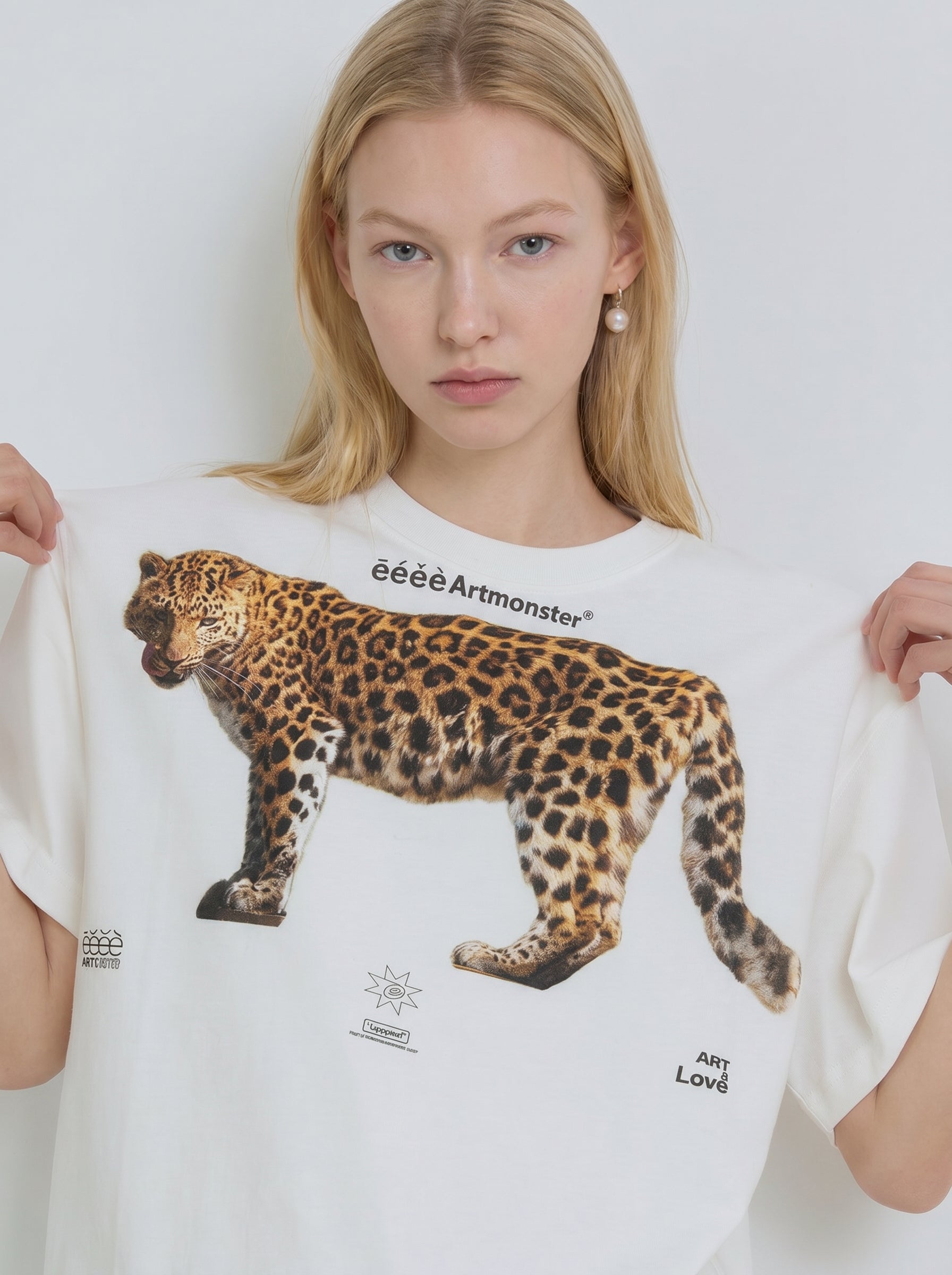 Close-up of white graphic T-shirt with leopard illustration, crew neckline, and relaxed cotton drape